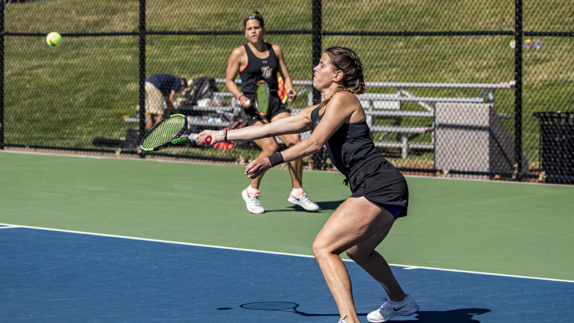 Caitlin (foreground) and Annie McCullough earned a doubles win for the Pioneers over Wingate (photo by Chuck Williams)