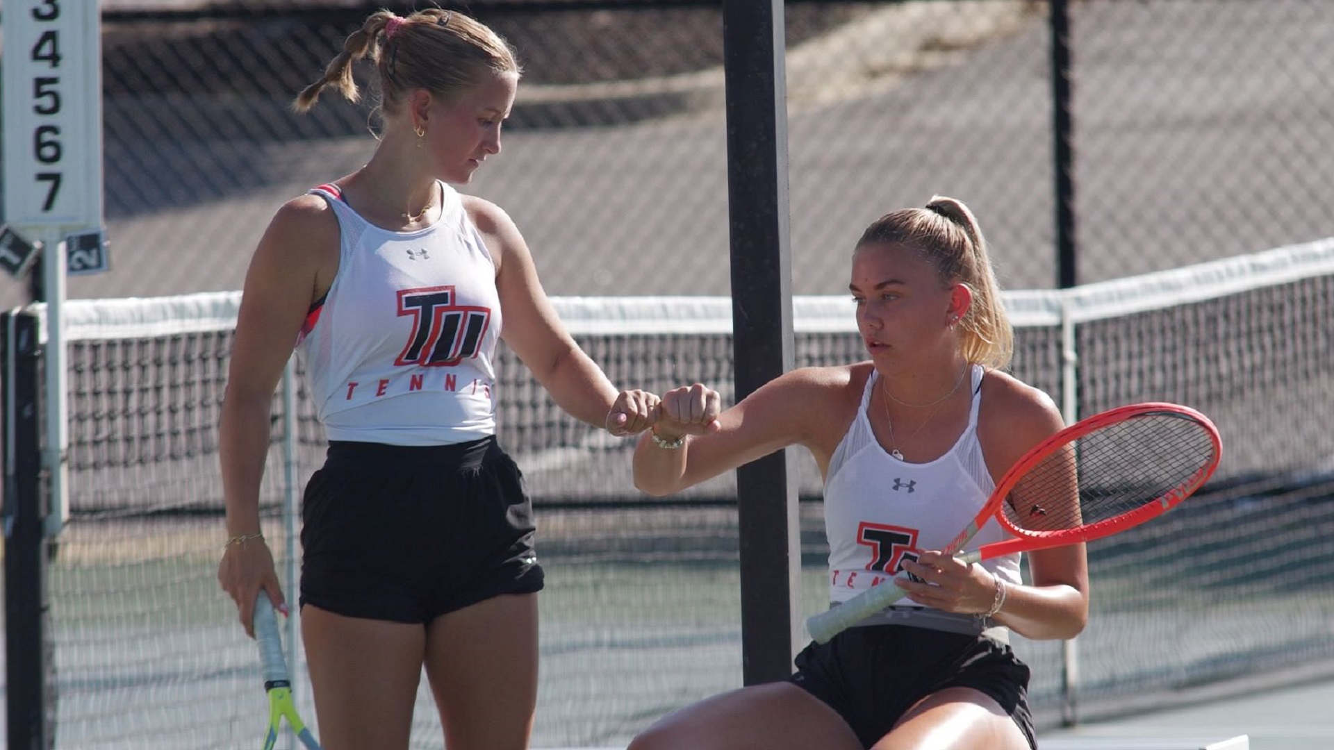 Ylva Frafjord Landa congratulates Leonie Floeth after the pair clinched the doubles point for Tusculum (photo by Chris Lenker)